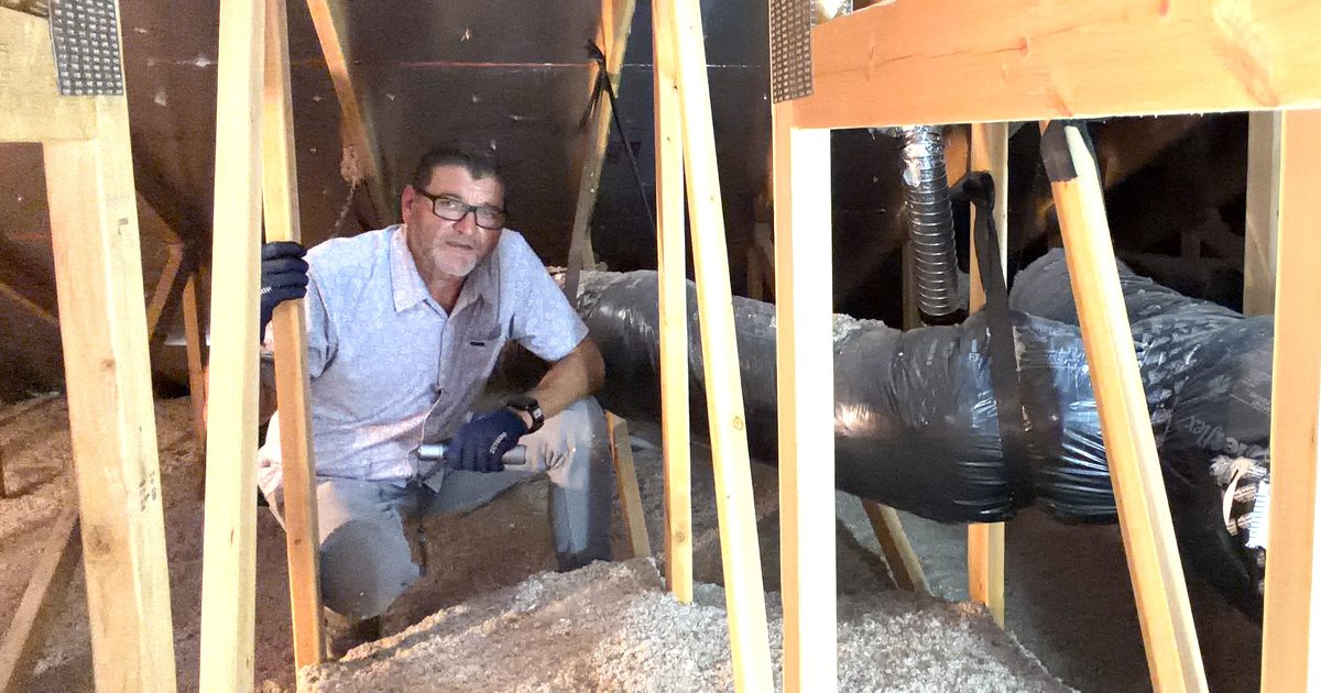 Kelly Lopez inspecting attic framing and ductwork for storm-related water intrusion in a Phoenix area home