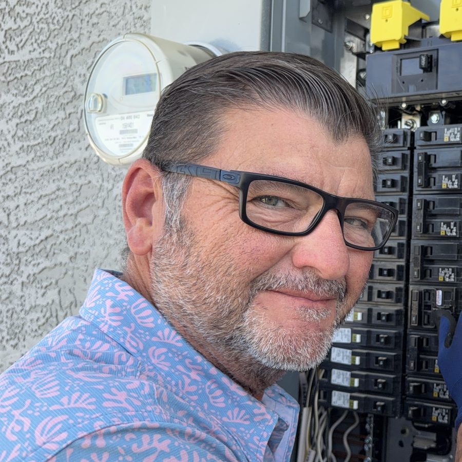 Kelly Lopez, owner of Leading Edge Plus Inspections, at an open 200-amp Square D service panel during a Gilbert, AZ home inspection