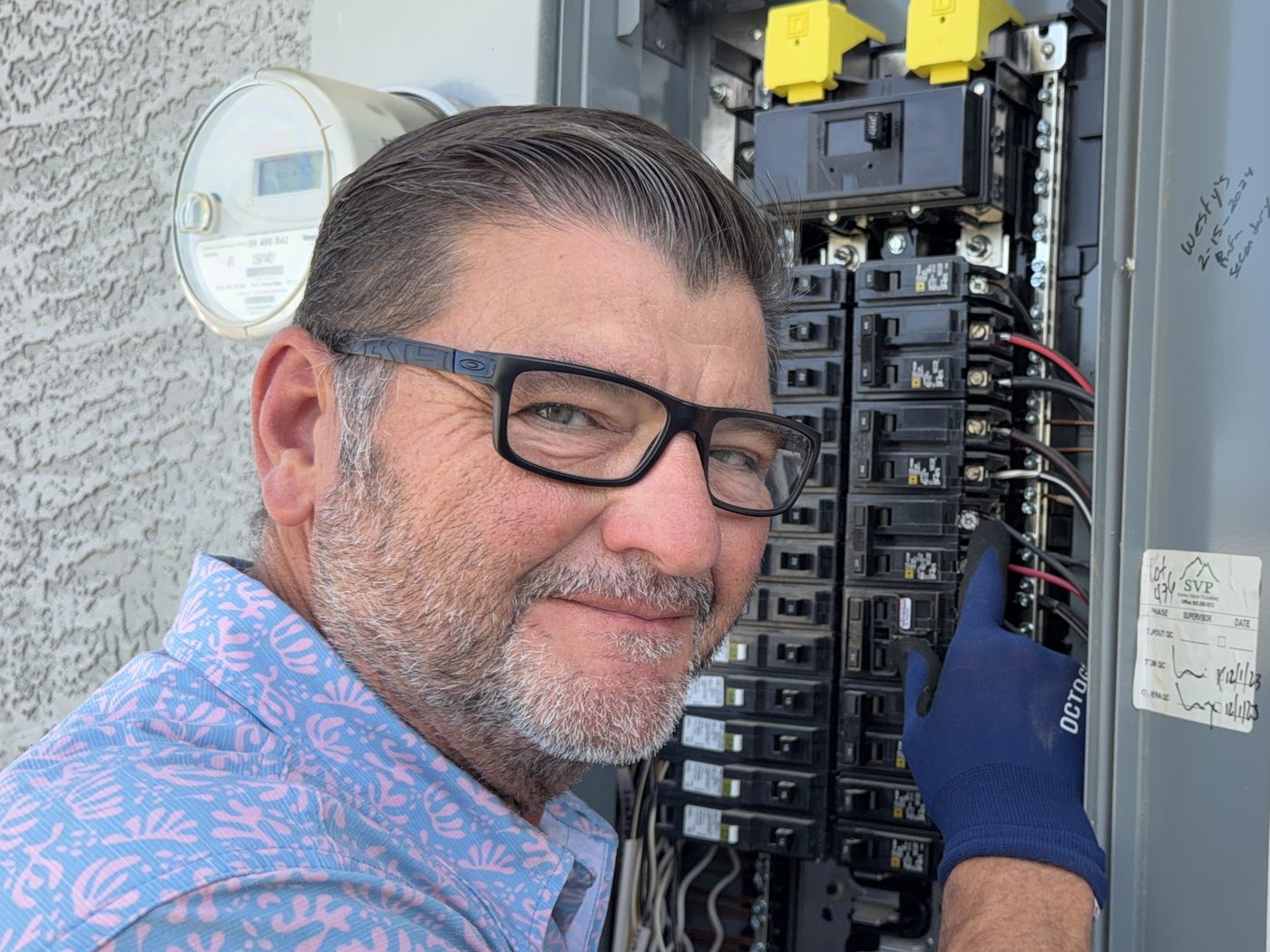 Kelly Lopez inspecting an open electrical service panel during a buyer home inspection in Gilbert, AZ