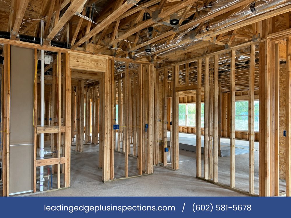 Interior wall framing, headers and roof trusses exposed before drywall on a new-construction home